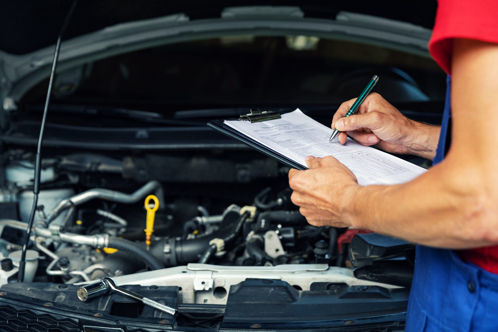 car maintenance and repair - mechanic writing checklist paper on clipboard copy space