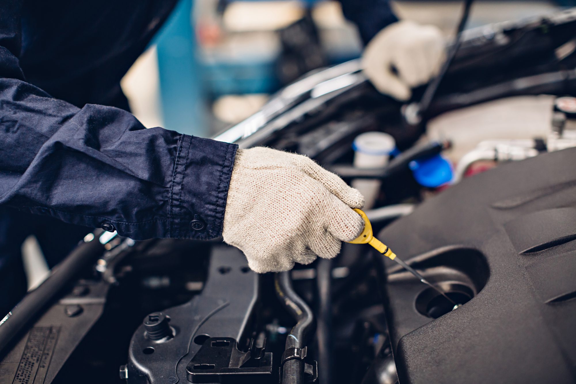 Car mechanic checking the oil in a car